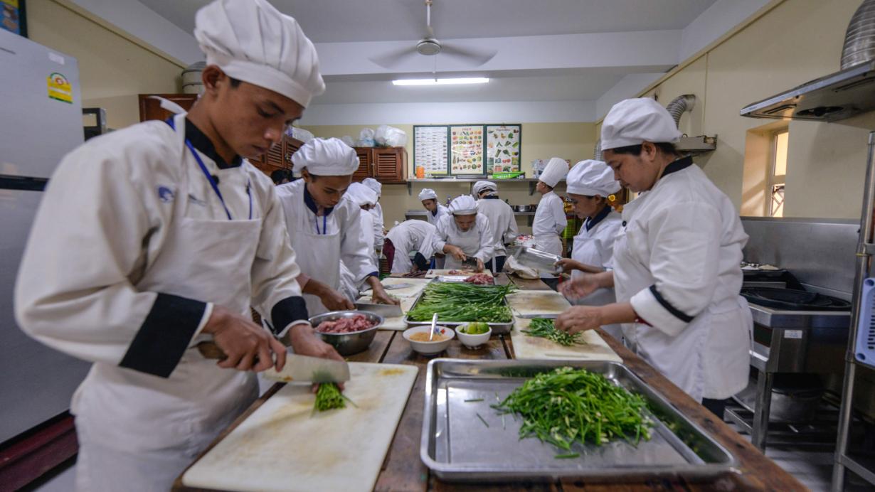 Des jeunes en formation professionnelle courte de cuisine en train de cuisiner