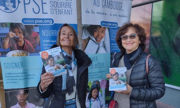 Deux bénévoles de l'opération minidon à Chatou, montrent le flyer distribué aux clients
