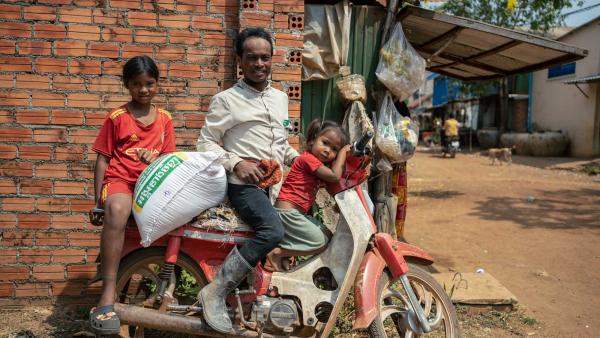 Une famille dans une communauté après avoir récupéré son sac de riz