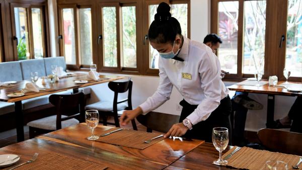 Une étudiante de PSE en train de dresser une table dans le restaurant d'application rénové de PSE