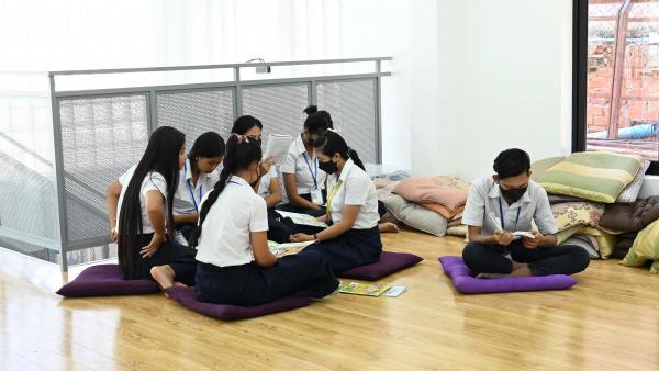 Des élèves en train de lire sur des coussins au sol dans la nouvelle bibliothèque de PSE