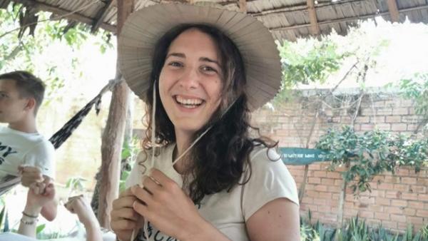 Hélène au Cambodge avec un chapeau de paille sous une paillote