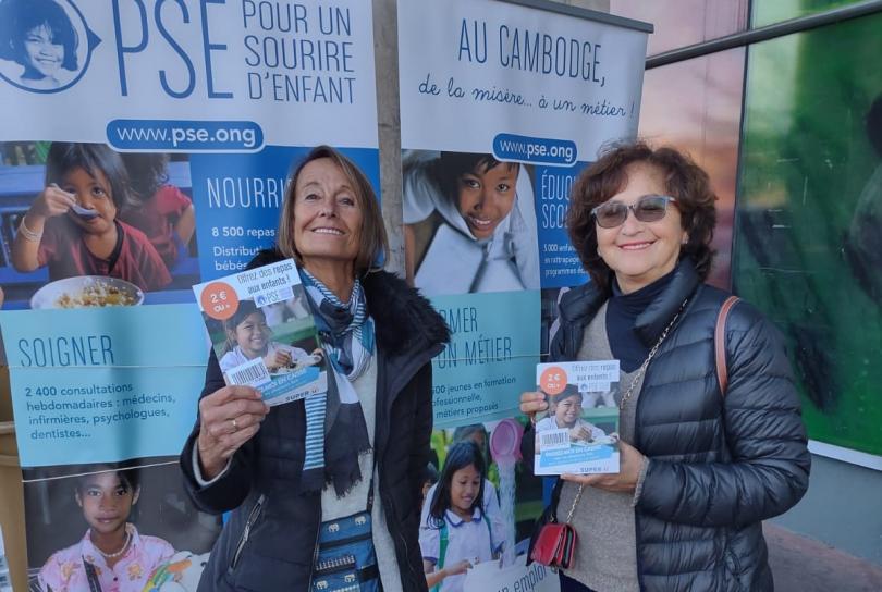 Deux bénévoles de l'opération minidon à Chatou, montrent le flyer distribué aux clients