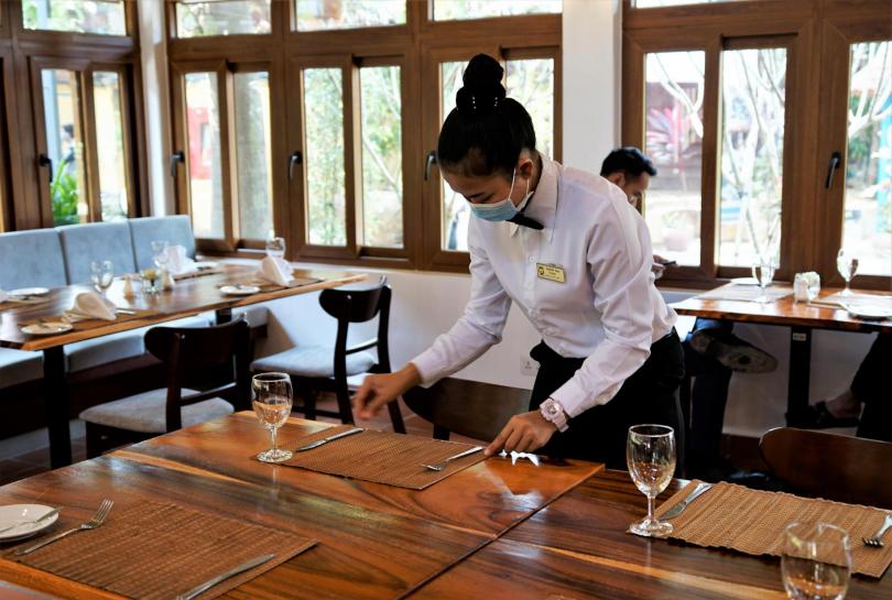 Une étudiante de PSE en train de dresser une table dans le restaurant d'application rénové de PSE