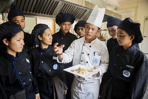 Des étudiants en formation cuisine autour de leur professeur