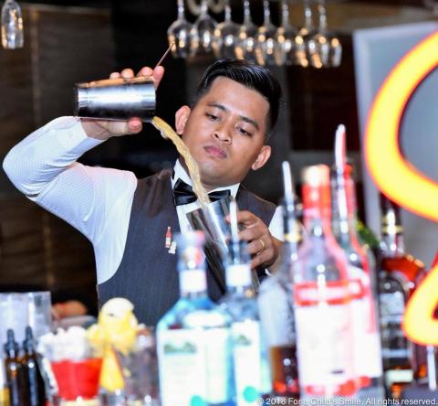 Lyheang en train de préparer un cocktail