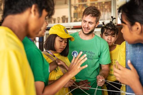 Des moniteurs lors d'une activité de tissage avec des jeunes