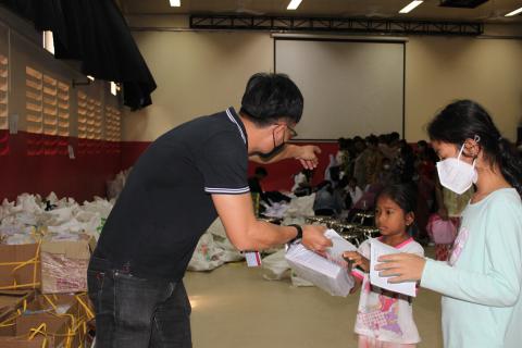 Un travailleur social de PSE aident deux petites filles à récupérer le matériel scolaire Un travailleur social de PSE aident deux petites filles à récupérer le matériel scolaire