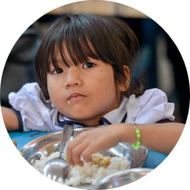 Nourrir Petite fille à la cantine qui mange du riz
