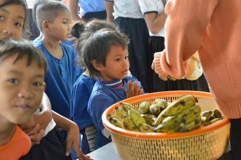 Des enfants des paillotes reçoivent des bananes pour le gouter Des enfants des paillotes reçoivent des bananes pour le gouter