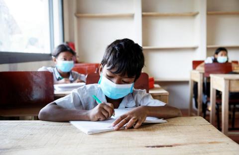 Un enfant en train de travailler dans sa nouvelle salle de classe Un enfant en train de travailler dans sa nouvelle salle de classe