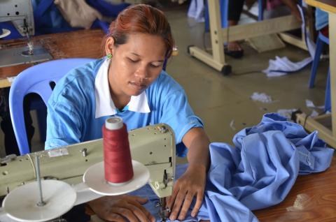 Une couturière de l'atelier couture de PSE confectionne une chemise