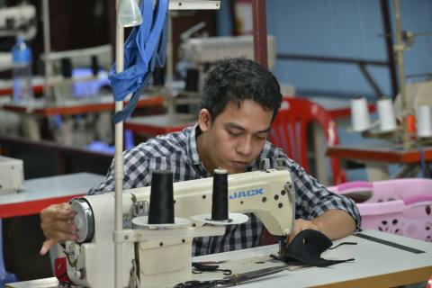 Un couturier de l'atelier couture de PSE confectionne un masque