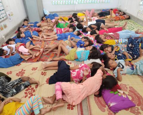 Des enfants font la sieste dans une salle de classe