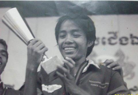 Leng, jeune en train de tenir un trophée