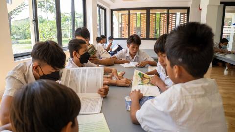 Un groupe d'enfants en train de lire dans la nouvelle bibliothèque Un groupe d'enfants en train de lire dans la nouvelle bibliothèque