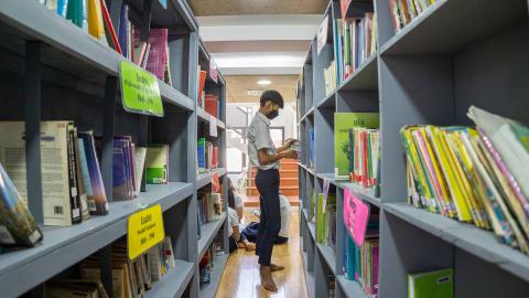 Un étudiant en train de chercher un livre Un étudiant en train de chercher un livre