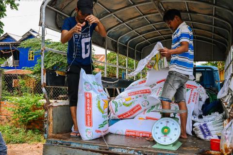 Deux travailleurs journaliers aident les assistants sociaux lors d'une distribution de riz à Oudong Deux travailleurs journaliers aident les assistants sociaux lors d'une distribution de riz à Oudong
