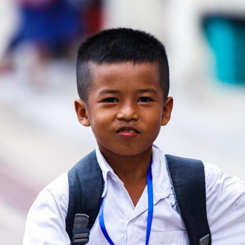 Un petit garçon en uniforme scolaire avec son cartable à PSE Petit garçon en uniforme