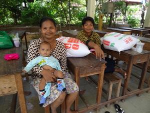 Une mère et ses deux enfants avec le riz reçu de la part de PSE Une mère et ses deux enfants avec le riz reçu de la part de PSE